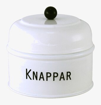 Foto av rund vit plåtburk med svart knopp och text