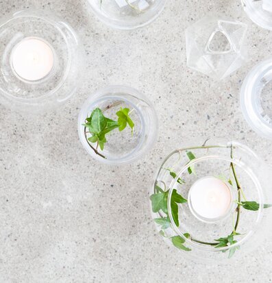 Bild av harmoniska glasföremål med ljus och växter