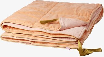 Foto av lyxig sammetsfilt i korall med gyllene detaljer