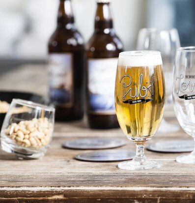 Bild av rustik och inbjudande miljö med ölglas i fokus