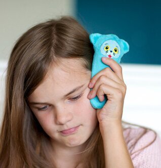 Bild av flicka med blå björnformad komfortprodukt