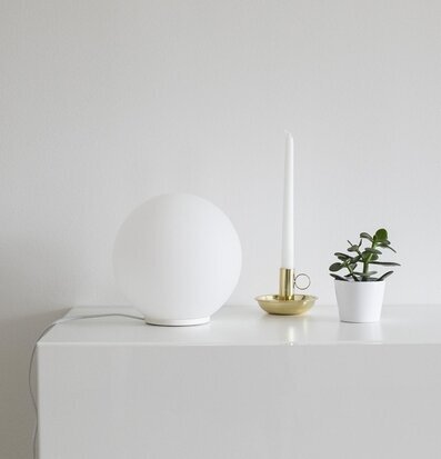 Bild av minimalistisk inredning med glaslampa och växt