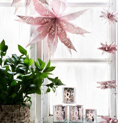 Bild av rosa stjärnor och ljuslyktor i fönsterkarm