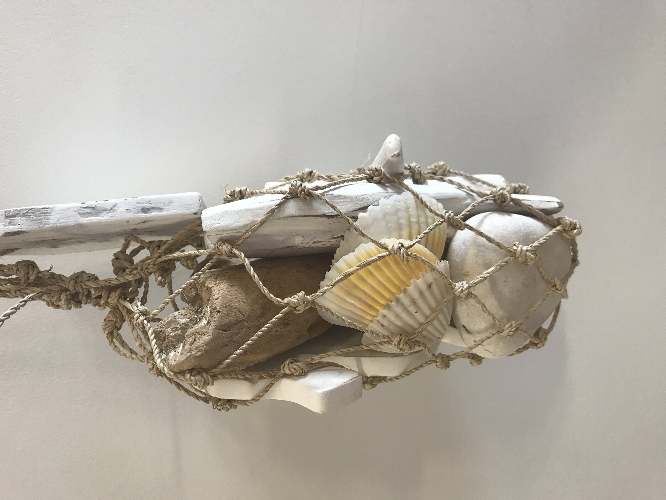 Bild av rustikt konstverk med snäckor och drivved