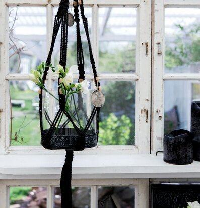 Bild av elegant inredning med makrame och glasvas