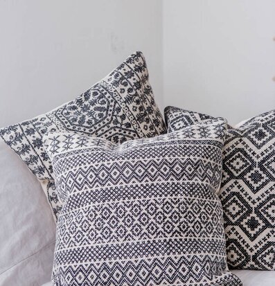 Foto av kuddar med geometriska mönster på ljus soffa