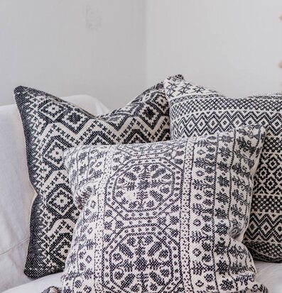 Bild av kuddar med aztekiskt mönster på vit soffa