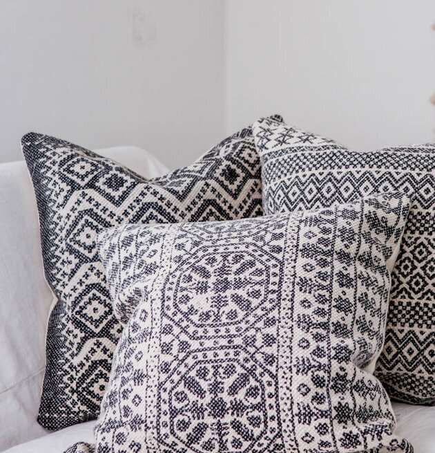 Bild av kuddar med aztekiskt mönster på vit soffa