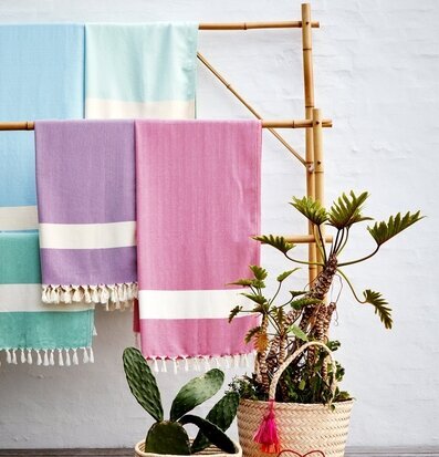 Bild av färgglada handdukar på rustik bambuställning