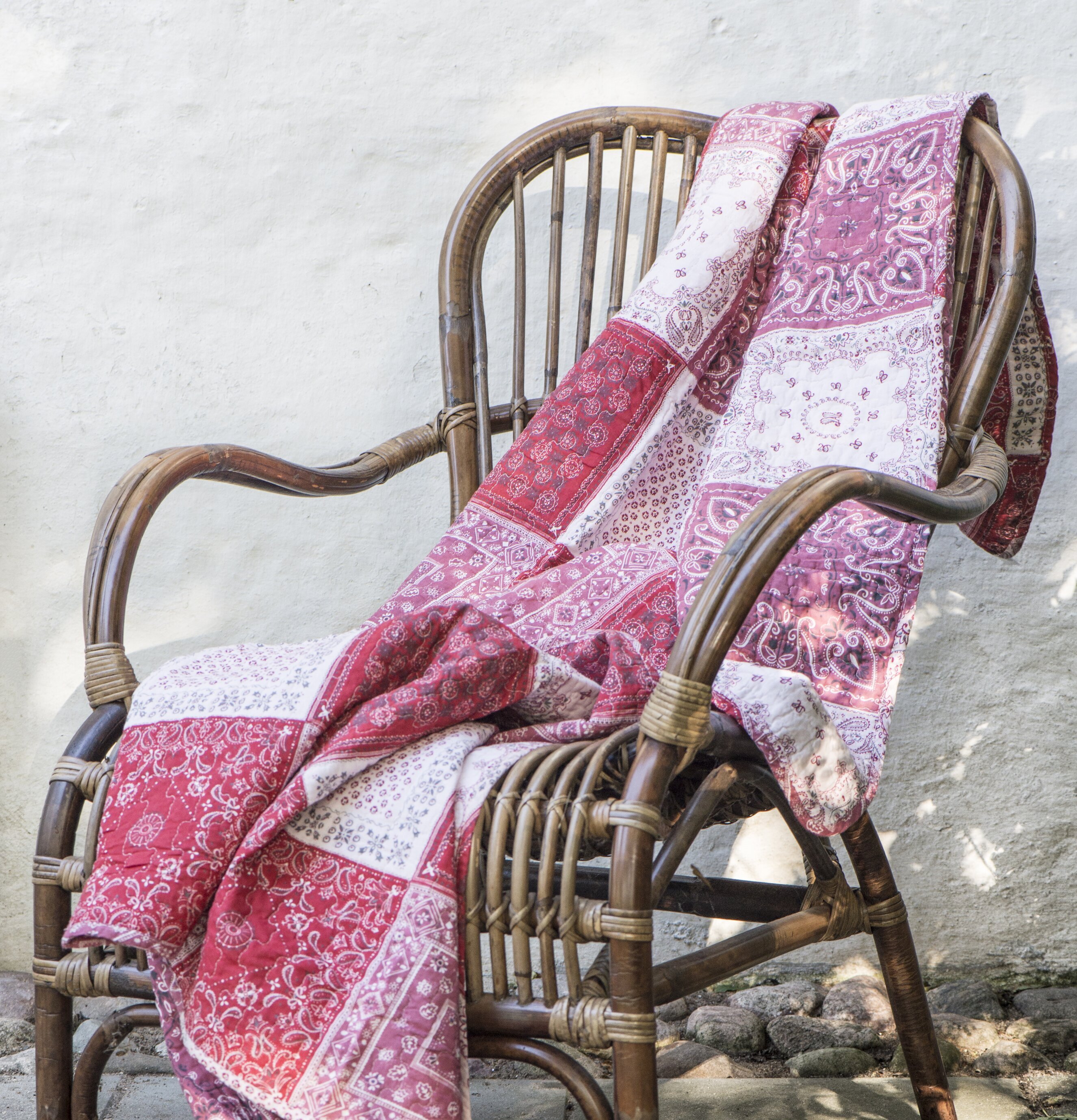 Pläd Patchwork Röd från IB Laursen på rottingstol uteplats