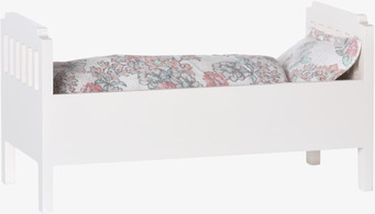 Bild av stilren liten säng med blommiga sängkläder