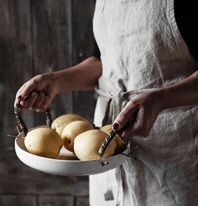 Foto av linneförkläde med citroner i skål i fokus