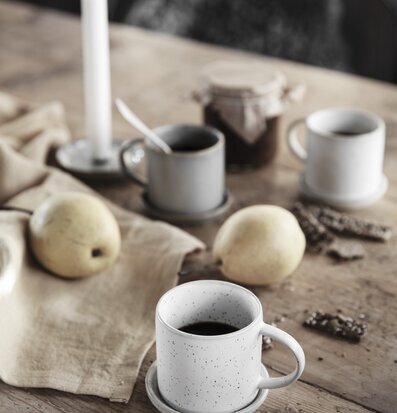 Bild av avkopplande fika med tekopp och stearinljus