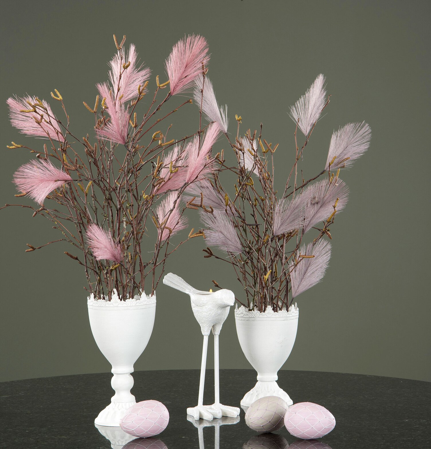 Bild av stilfullt arrangemang med rosa fjädrar och urnor