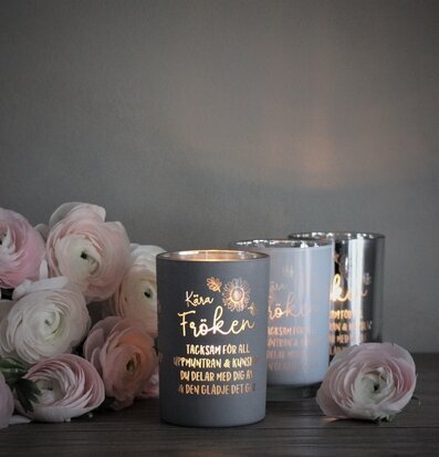 Bild av dekorativa ljuslyktor med blommor i förgrunden