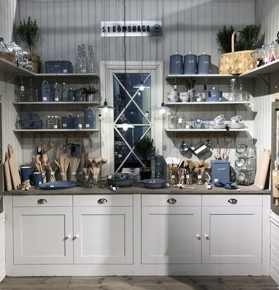 Bild av vackert arrangerad butikshylla med köksartiklar