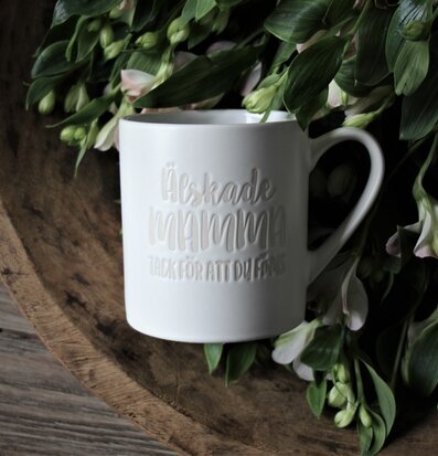 Bild av mugg med kärleksfullt budskap och blommor