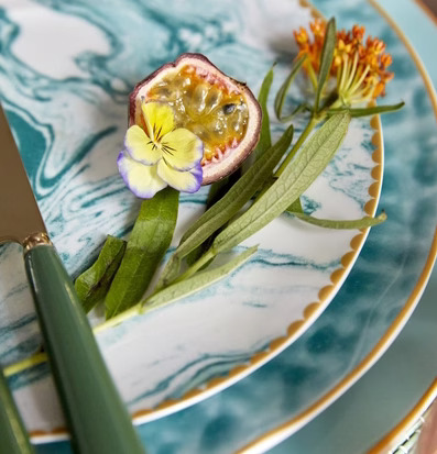 Bild av elegant dukning med marmormönstrad tallrik