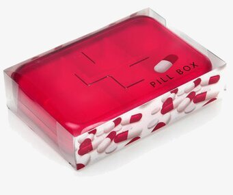 Foto av livfull röd pillerask i klar plastförpackning