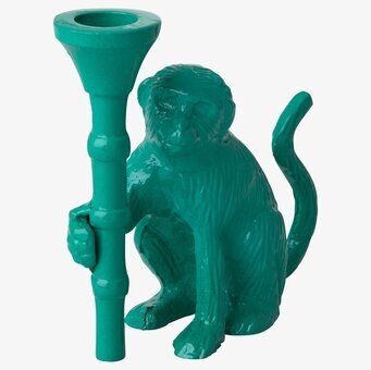 Foto av grön ljusstake i form av en apa med bambustav