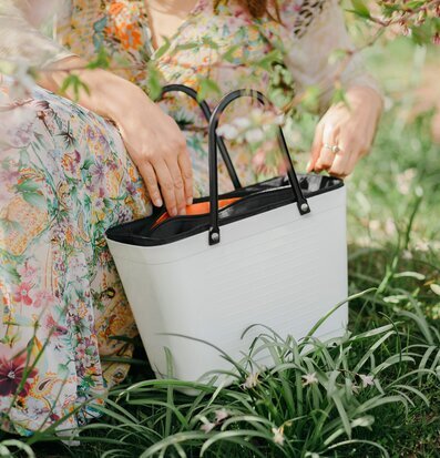 Bild av somrig scen med färgglad klänning och väska