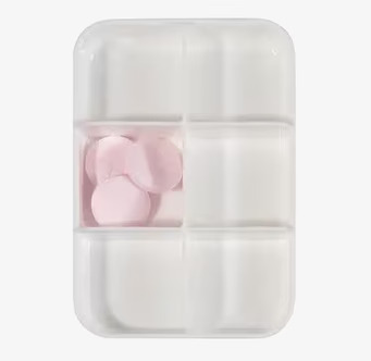 Bild av vit pillerask med sex fack och rosa tabletter