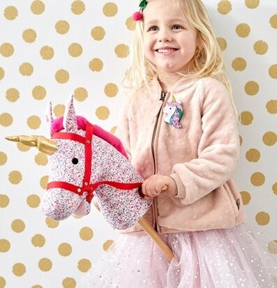 Bild av barn med färgglad käpphäst i fantasifull miljö