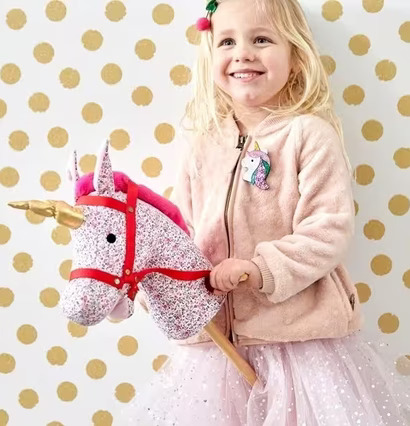 Bild av barn med färgglad käpphäst i fantasifull miljö