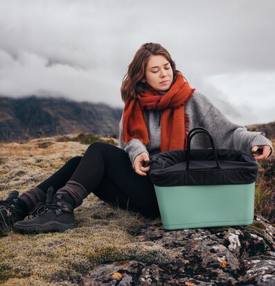 Bild av kvinna i natur med praktisk och stilren väska