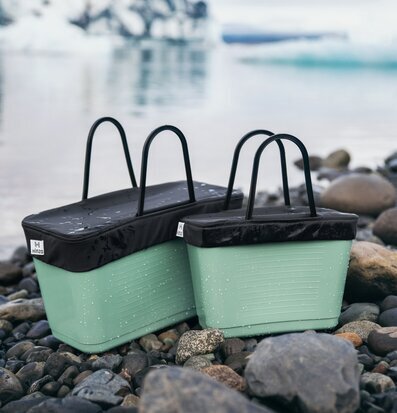 Bild av stilrena väskor i naturskön miljö vid sjö