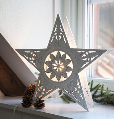 Bild av dekorativ stjärnlampa i trä på fönsterbräda