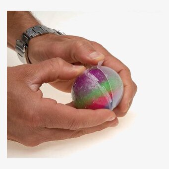 Bild av färgglad studsboll i händer med neutral bakgrund