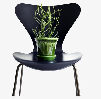 Bild av elegant grön kruka på stol med växtarrangemang