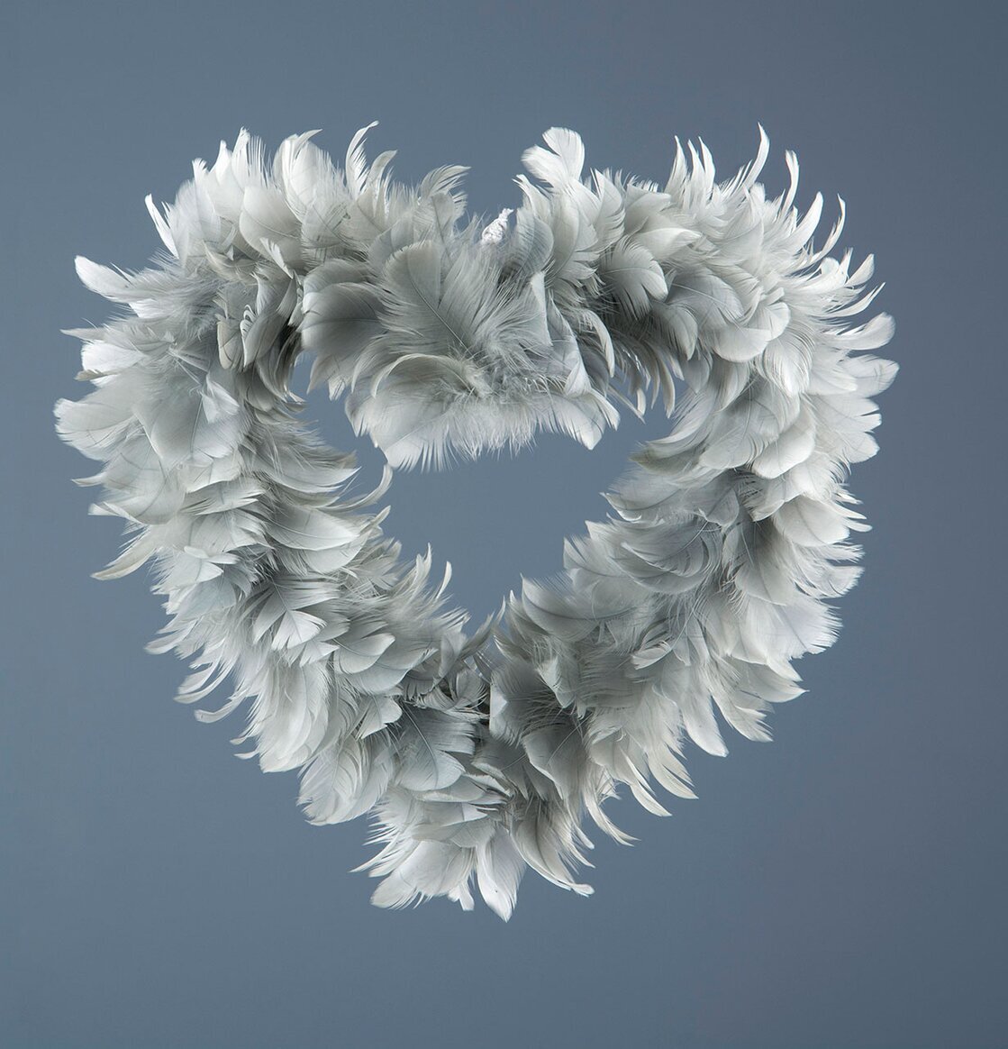 Bild av dekorativt hjärta i grå fjädrar för hemmet