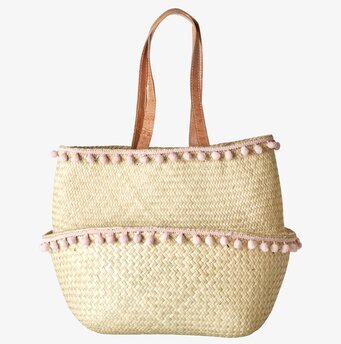 Bild av handflätad korg med pompoms i rosa nyans