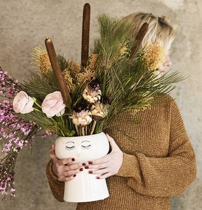 Bild av elegant blomsterarrangemang i stilren kruka