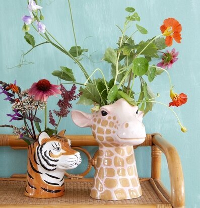 Bild av dekorativa vaser med blommor på rottinghylla