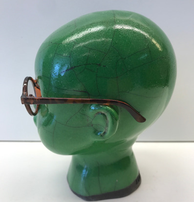 Foto av grön mannequin med glasögon och vit bakgrund