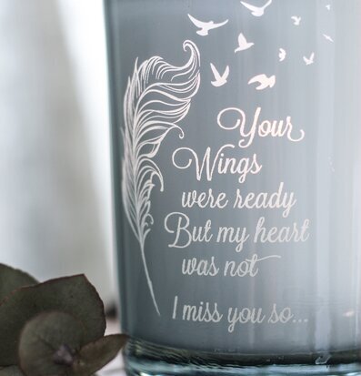 Bild av ljuslykta med gravyr och naturliga detaljer