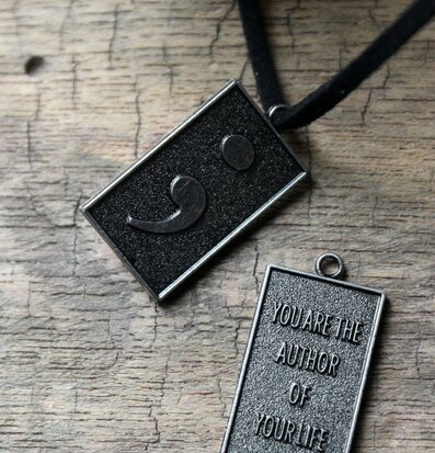 Bild av halsband med berlocker och inspirerande text