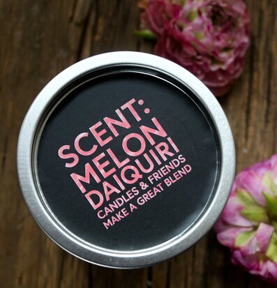 Bild av doftljus i metallisk behållare med blommor