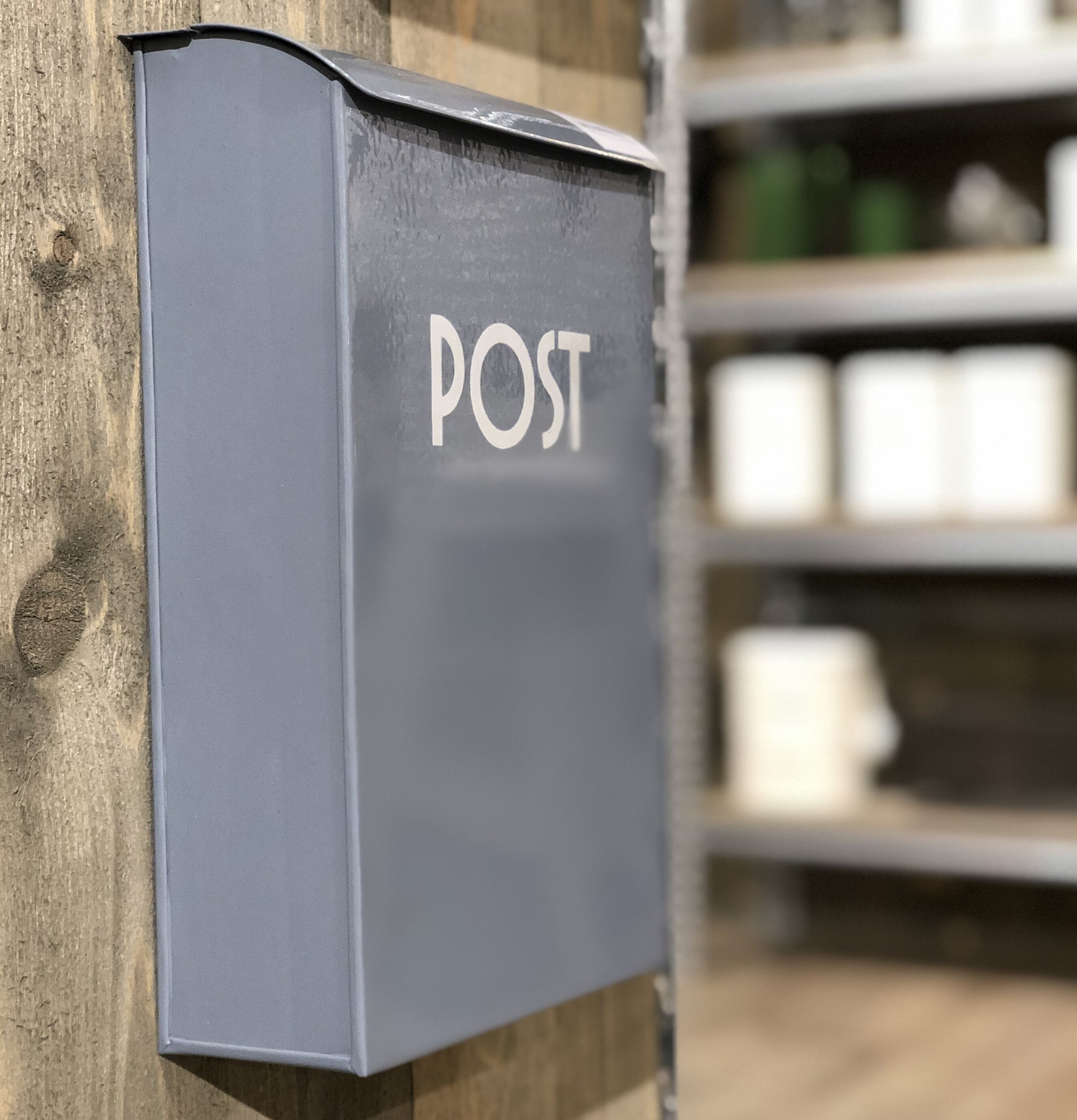 Postlåda Blå från Strömshaga monterad på rustik trävägg