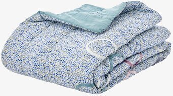 Foto av en filt med blått blommönster och gröna blad