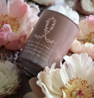 Bild av ljuslykta med rosa bandet och blommor