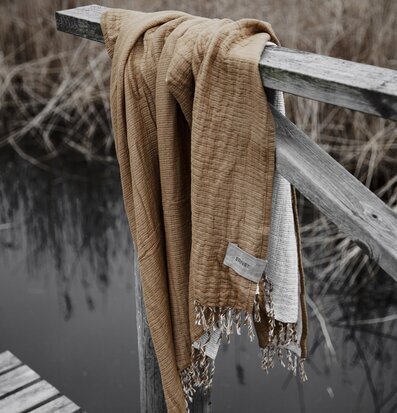 Bild av stämningsfull scen med bomullspläd vid brygga