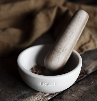 Foto av stilfull mortel i vit stengods på träbord