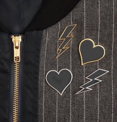 Foto av jacka med gyllene dragkedja och stilfulla pins