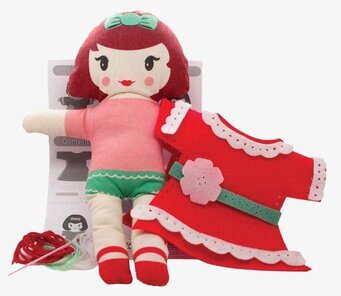 Bild av charmig docka med sömnadstillbehör och kläder