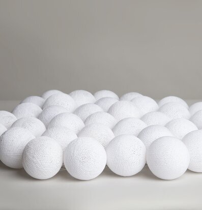 Bild av stilren ljusslinga med vita bollar i fokus