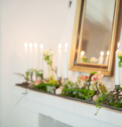 Bild av elegant ljusstake med tända ljus och blommor